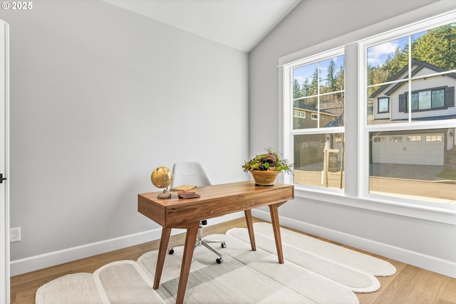 office area with light hardwood / wood-style floors and vaulted ceiling