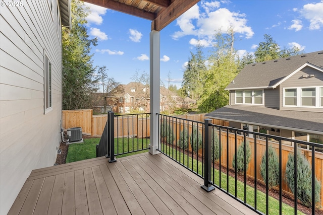 wooden deck featuring a lawn and central AC unit