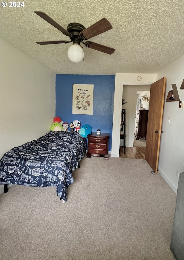 carpeted bedroom featuring a textured ceiling and ceiling fan