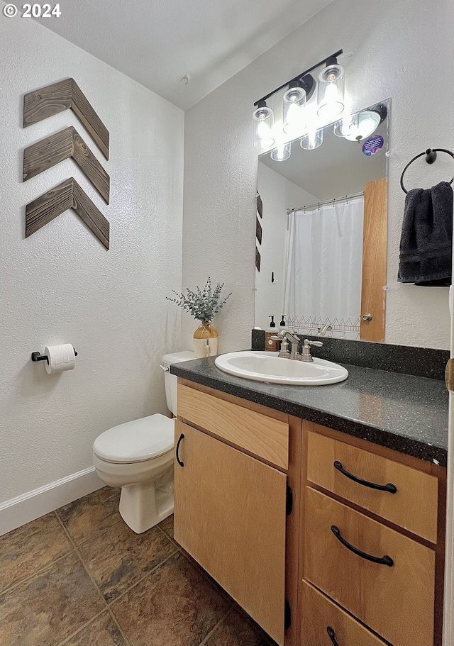 bathroom featuring toilet, vanity, and tile patterned floors