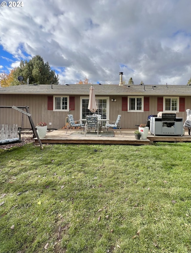 rear view of property with a deck and a yard