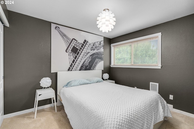 bedroom featuring light carpet and a chandelier