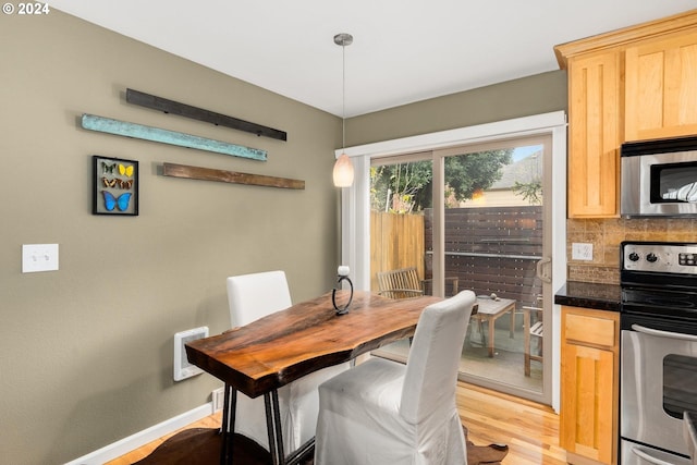 dining space with heating unit and light hardwood / wood-style floors