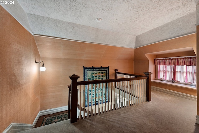 interior space with vaulted ceiling, a textured ceiling, and carpet flooring