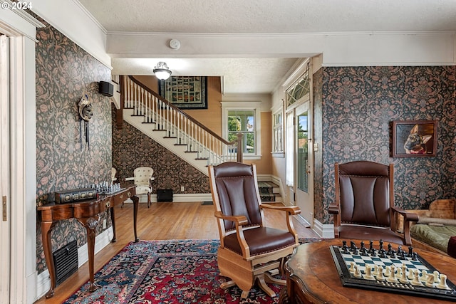 interior space featuring a textured ceiling, crown molding, and wood-type flooring