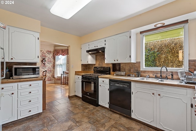 kitchen featuring black appliances, plenty of natural light, white cabinetry, and sink