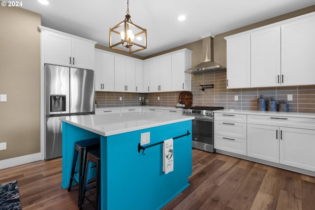 kitchen featuring a center island, dark wood-type flooring, wall chimney exhaust hood, appliances with stainless steel finishes, and white cabinetry