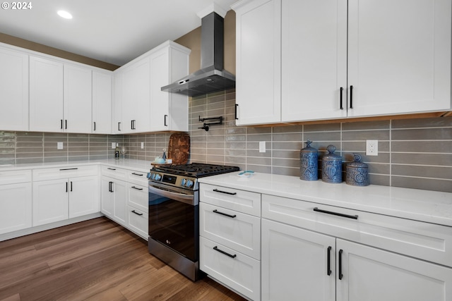 kitchen with backsplash, white cabinets, stainless steel range with gas cooktop, wall chimney exhaust hood, and dark hardwood / wood-style flooring