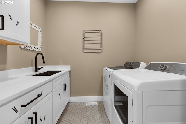 laundry area featuring cabinets, light tile patterned floors, separate washer and dryer, and sink