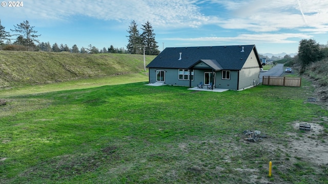 back of property with a lawn and a patio