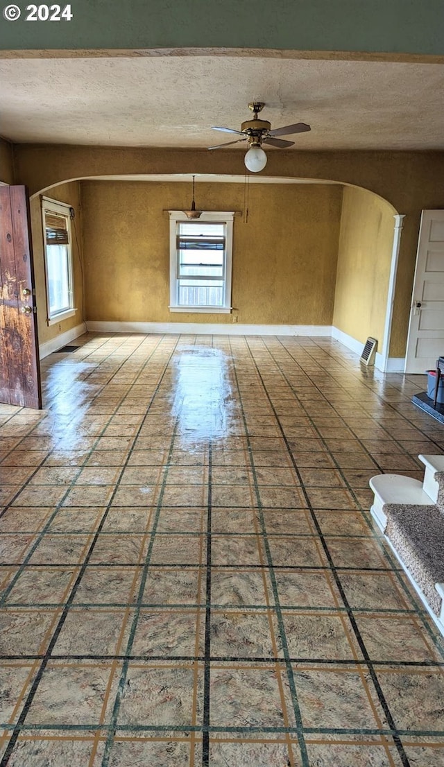 unfurnished room featuring a textured ceiling and ceiling fan