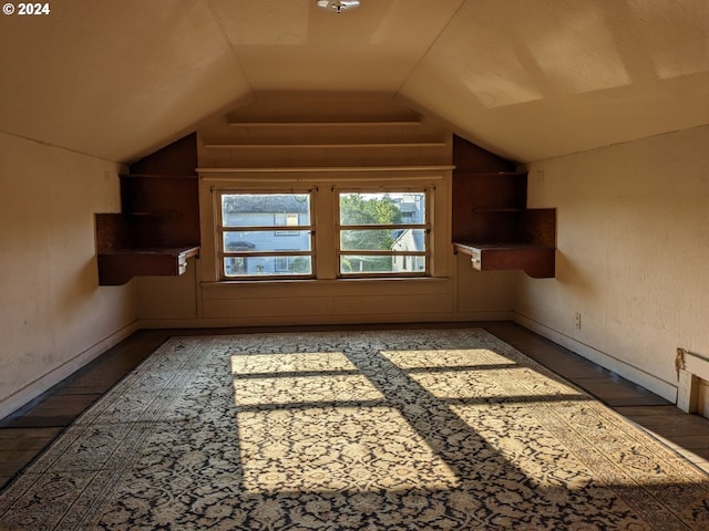 additional living space featuring hardwood / wood-style floors and vaulted ceiling