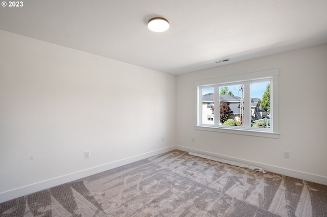 unfurnished room featuring light carpet