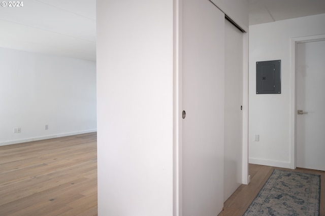 hallway with electric panel and light wood-type flooring