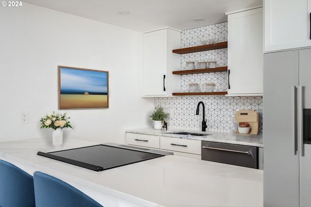 kitchen featuring open shelves, decorative backsplash, white fridge with ice dispenser, white cabinetry, and a sink