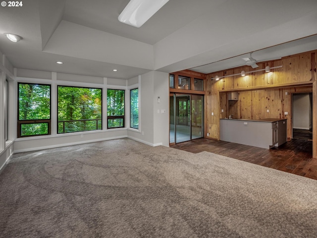 4731 SW 18th Dr, Portland, OR 97239 - unfurnished living room featuring wooden walls, dark carpet, ceiling fan, and a raised ceiling
