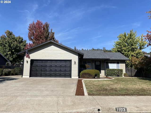 ranch-style home with a front lawn and a garage