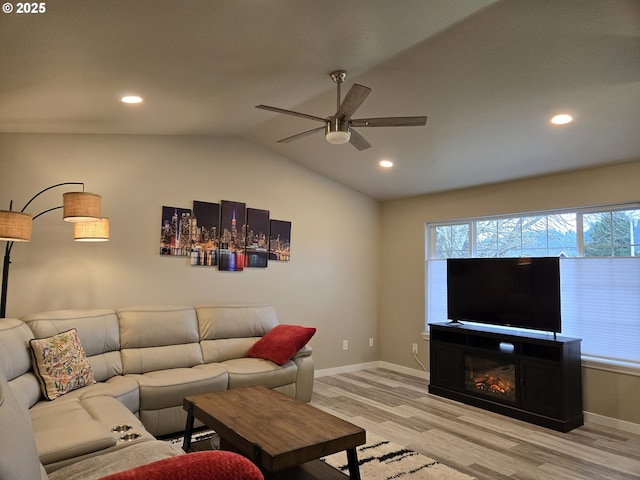 living room featuring ceiling fan, light hardwood / wood-style floors, and vaulted ceiling