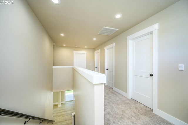 unfurnished bedroom with ceiling fan, ensuite bathroom, light colored carpet, and lofted ceiling