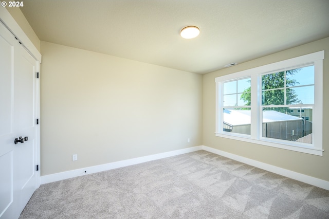 unfurnished bedroom with light carpet and multiple closets