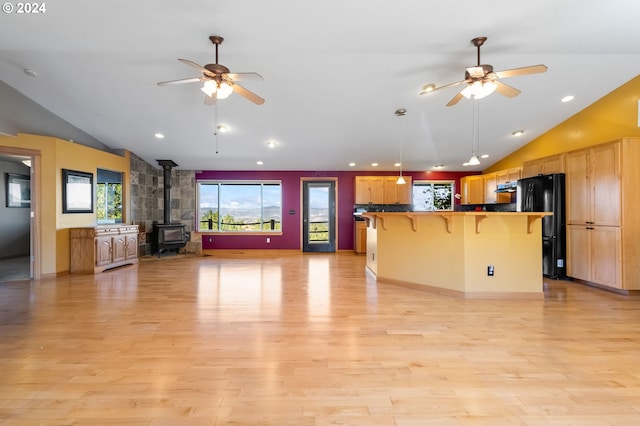 6997 SE Scenic Dr, Prineville, OR 97754 - kitchen with a wood stove, freestanding refrigerator, open floor plan, and a ceiling fan