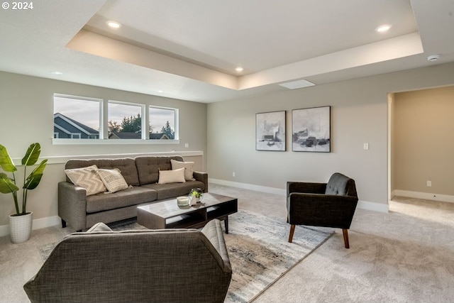 living room with a raised ceiling and light colored carpet