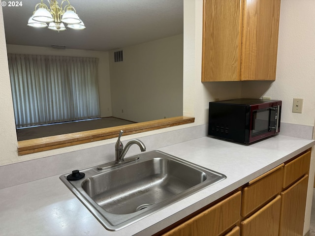 kitchen with sink, hanging light fixtures, and a notable chandelier