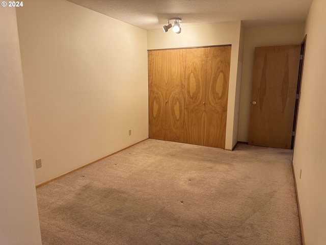 unfurnished bedroom featuring carpet, a closet, and a textured ceiling