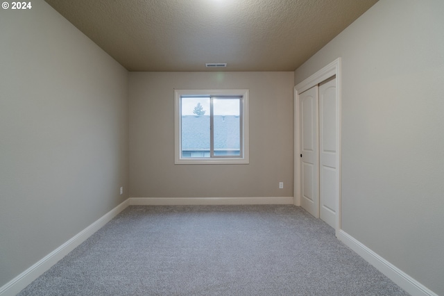 spare room with a textured ceiling and carpet floors