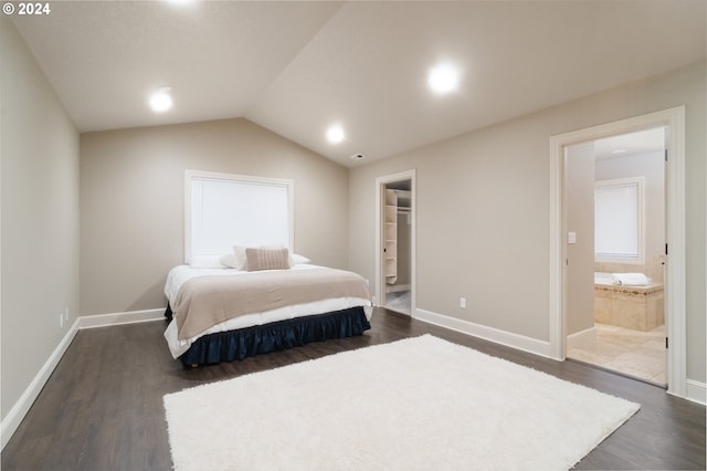 bedroom featuring ensuite bathroom, lofted ceiling, a walk in closet, and dark hardwood / wood-style floors