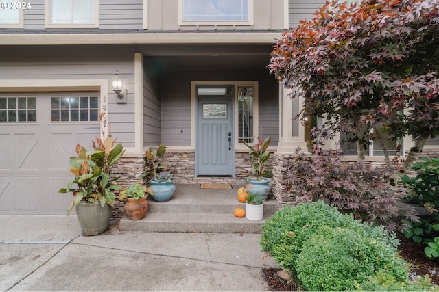 property entrance with covered porch and a garage