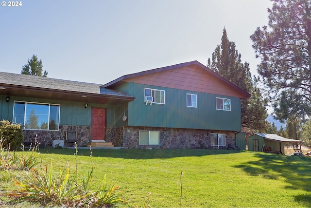 tri-level home featuring a front lawn and a shed