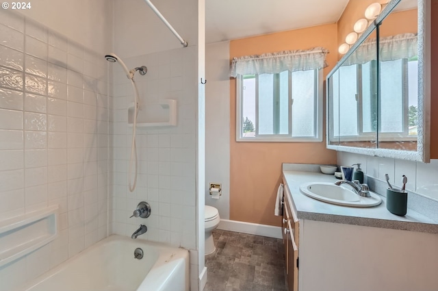 full bathroom featuring tile patterned floors, vanity, tiled shower / bath, and toilet