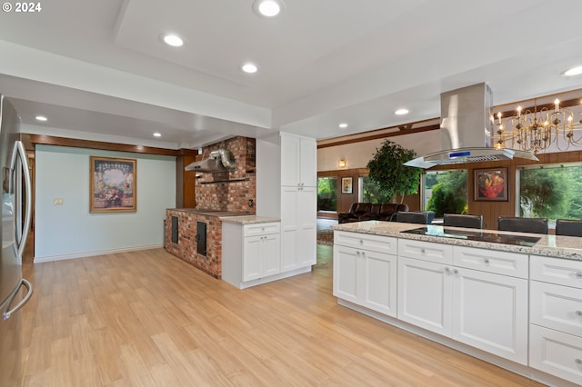 kitchen featuring black electric cooktop, light stone counters, white cabinetry, and island exhaust hood