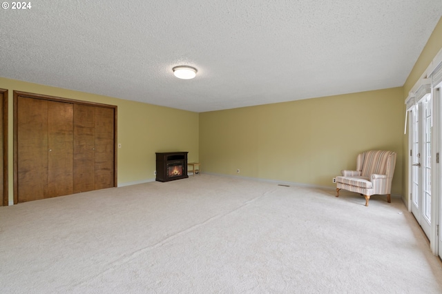 interior space featuring a fireplace, light carpet, and a textured ceiling