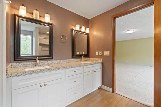 bathroom with wood-type flooring, a textured ceiling, and vanity