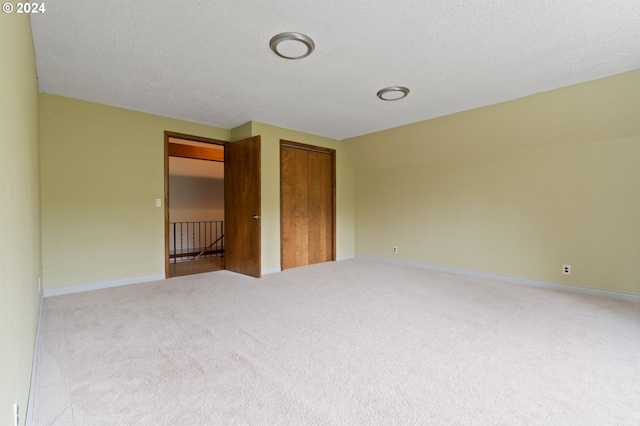 unfurnished bedroom featuring a closet, a textured ceiling, and carpet flooring