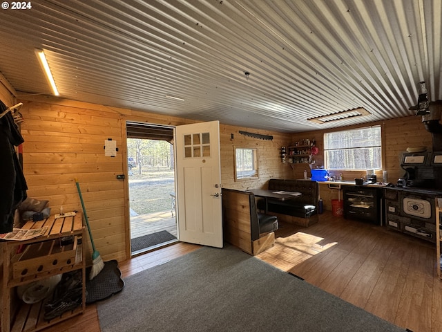 office area featuring plenty of natural light, wooden walls, and dark wood-type flooring