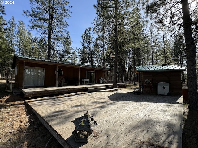 back of property featuring a wooden deck and an outdoor structure