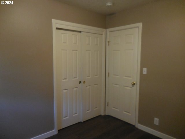 unfurnished bedroom featuring dark hardwood / wood-style floors and a closet