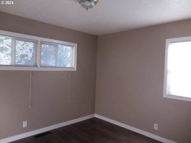 spare room with dark hardwood / wood-style floors