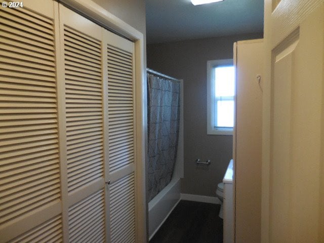 bathroom with shower / bath combination with curtain and toilet