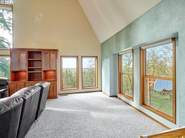 living room with light carpet, high vaulted ceiling, and a wealth of natural light