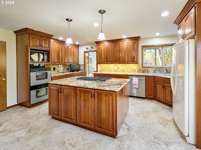 kitchen with light stone countertops, backsplash, appliances with stainless steel finishes, a center island, and pendant lighting