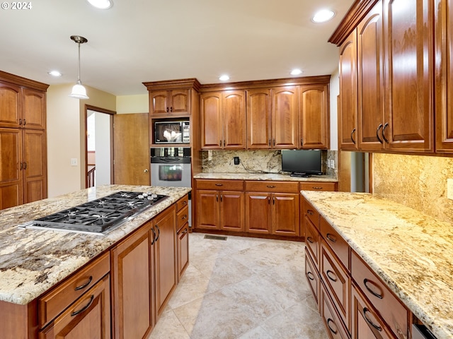 kitchen with hanging light fixtures, light stone counters, stainless steel appliances, backsplash, and light tile floors