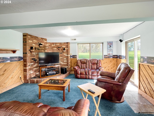 living room featuring a textured ceiling, brick wall, a healthy amount of sunlight, and light tile flooring