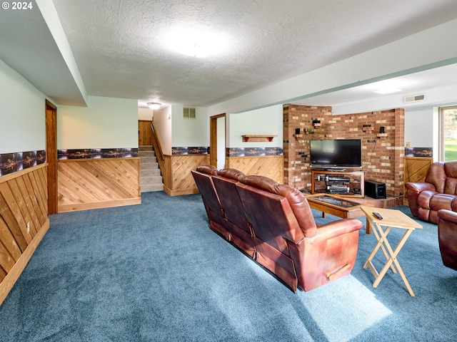 living room featuring a textured ceiling, brick wall, and carpet