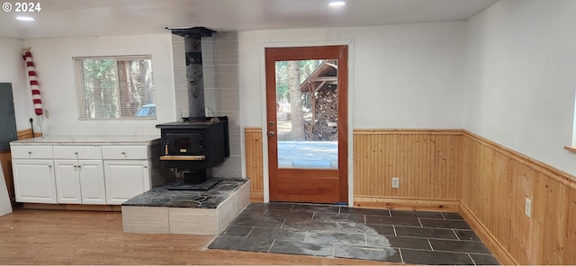 doorway with dark hardwood / wood-style floors and a wood stove