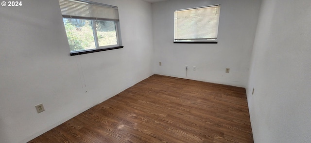 empty room with dark hardwood / wood-style flooring