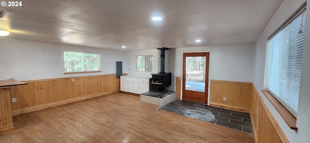 kitchen with a wood stove, dark wood-type flooring, and kitchen peninsula